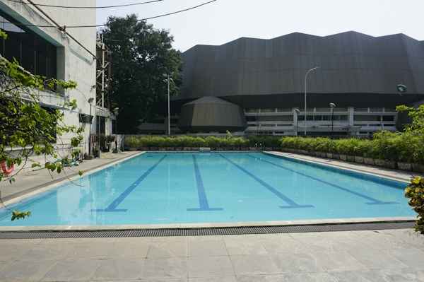 Piscina exterior vacía con líneas de nado y agua azul